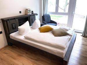 a large bed with pillows and a chair in a room at Igelnest Großthiemig in Großthiemig