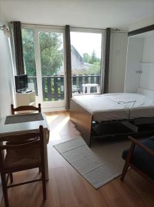 a bedroom with a bed and a large window at Studio tout confort au bord du lac d'Estey avec parking privé in Dax