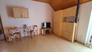 Cette chambre comprend une cuisine avec une table et une télévision. dans l'établissement Apartment Siofok, Lake Balaton 16, à Somogyfok