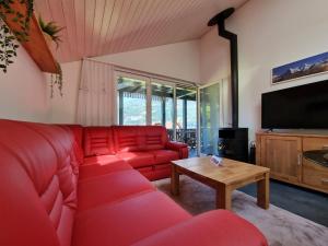 a living room with a red couch and a coffee table at Seeparadiesli am schönen Thunersee in Därligen