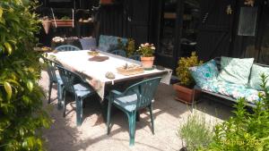 a table and chairs and a couch in a yard at petit chez soi dans mon petit chez moi in Biganos