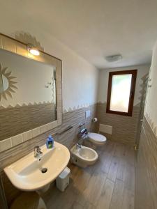 オルビアにあるMolti Mari B&B Resortのバスルーム(洗面台2台、トイレ、鏡付)