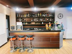 un bar con taburetes naranjas en una habitación en Full House en Jinning