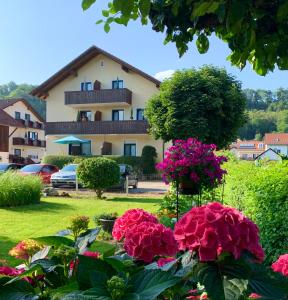 a house with pink flowers in a yard at Gästehaus Biedermann in Kinding