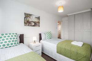 Duas camas num quarto com paredes brancas em Tms Lovely 3 Bed House-Tilbury-Free parking em Tilbury