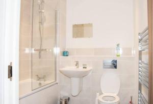 y baño con aseo, lavabo y ducha. en TMS Beautiful 2BR Apartment! Ensuite! Lakeside, en West Thurrock