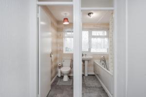 a bathroom with a toilet and a sink at Tms Lovely 3 Bed House-Tilbury-Free parking in Tilbury
