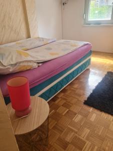 a bed sitting in a room with a table at Apartment Delta Sava New Belgrade in Belgrade
