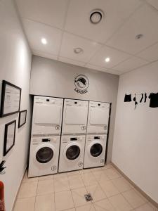 a laundry room with three washer and dryers at Résidence Néméa mondial 98 in Montpellier