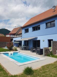 ein Haus mit einem Swimmingpool davor in der Unterkunft Gîte à la Source in Breitenbach