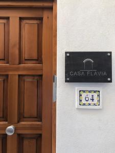 Una puerta a un edificio con un cartel. en Casa Flavia, en Anacapri
