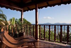 a porch with a chair and a view of the ocean at Lakaz An Bwa in La Digue +27 photos