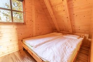 ウェバにあるDomki Zacisze Łebyのログキャビン内の木造の部屋のベッド1台分です。