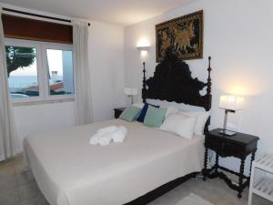a bedroom with a large white bed with a window at Luz Beach Center in Luz