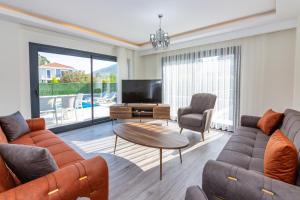 a living room with a couch and a tv and a table at Villa Angel B Camdibi Marmaris Family only in Marmaris