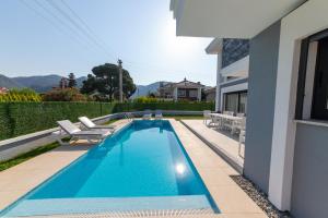 a swimming pool with chairs and a house at Villa Angel B Camdibi Marmaris Family only in Marmaris