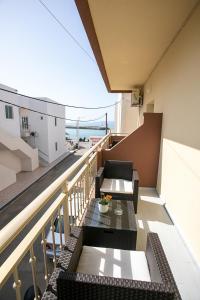 a balcony with tables and chairs on a building at Rania Studios in Gouves