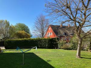 un patio con un árbol y una casa roja en Neu ab 2022: Schöne Ferienwohnung in Top-Lage 84m2, en Langenargen