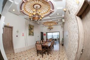 a dining room with a table and chairs and a chandelier at Nhar Accommodation House in Sohar