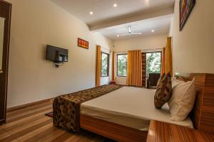 a bedroom with a large bed and a tv at Bajoon homestay in Bhīm Tāl