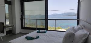 a bedroom with a bed with a view of the ocean at Ionian Sea Villas in Paleros