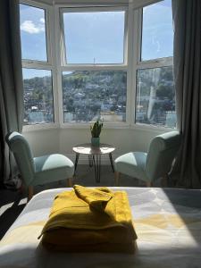 a bedroom with a bed and two chairs and a table at Penwyn Bed and Breakfast in Looe