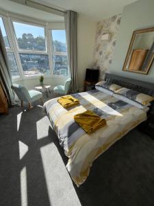 a bedroom with a bed with yellow towels on it at Penwyn Bed and Breakfast in Looe