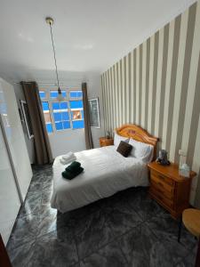 um quarto com uma cama, uma mesa e uma janela em Pico Lomito House em Moya