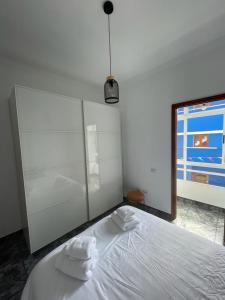 a bedroom with a white bed with towels on it at Pico Lomito House in Moya