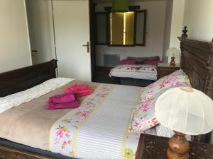 Montreuil-sur-BrêcheにあるAu Bol d'Éireのベッドルーム1室(ピンクの枕とランプ付きのベッド1台付)