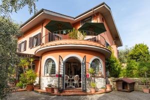 Una casa grande de color naranja con balcón en la parte superior. en La Tana delle Stelle B&B di Charme e Relax, en Fara in Sabina