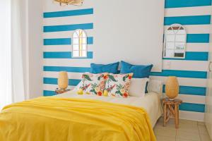 um quarto com uma cama com riscas azuis e brancas em Oliva Holiday Homes em Dhiyeliótika