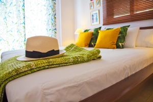 a hat and a green dress on a bed at Oliva Holiday Homes in Dhiyeliótika