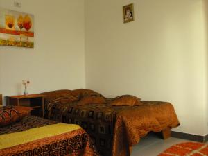 a bedroom with two beds and a table and a picture on the wall at Casa Rustica Apart & Rooms in Cîmpineanca