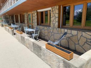 a stone building with tables and chairs outside of it at Mon nid montagnard au soleil in Les Deux Alpes