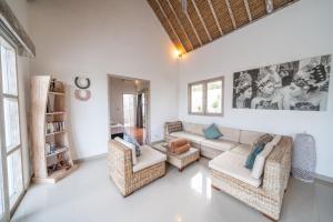 un salon avec un canapé et des chaises dans l'établissement Villa Bali Paradis, à Jimbaran