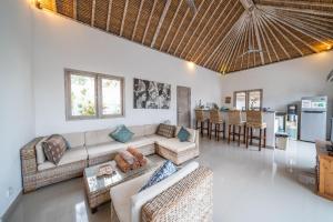 un salon avec un canapé et des chaises et une cuisine dans l'établissement Villa Bali Paradis, à Jimbaran