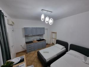 una camera con due letti e una cucina con luci di Studio Vlora a Vlorë