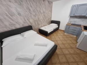 una camera da letto con un letto bianco e una cucina di Studio Vlora a Vlorë