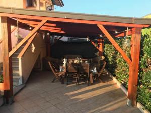 patio con tavolo e sedie sotto un pergolato di Enza-home-in-ROMA a Borghesiana