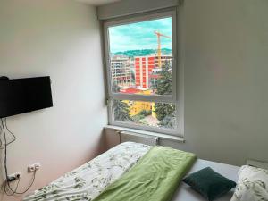 a bedroom with a bed and a large window at Stan na dan Bella in Banja Luka