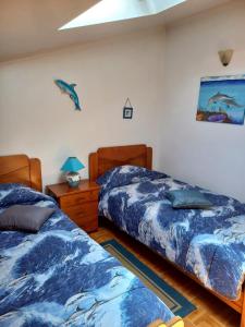 Un dormitorio con dos camas y un cuadro en la pared. en Beach House Above the Ocean AA3, en Ericeira