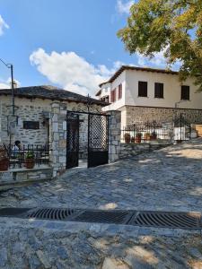 ein Gebäude mit einem Tor vor einem Haus in der Unterkunft ΘΕΤΙΣ in Vyzítsa