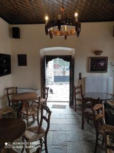 a dining room with tables and chairs and a chandelier at ΘΕΤΙΣ in Vyzitsa