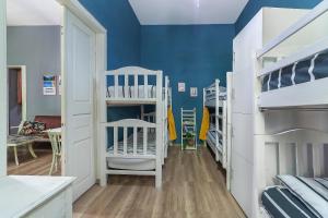 Habitación con paredes azules y literas blancas. en Doki House, en Tiflis