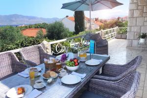 a table with plates of food on a patio at Apartment Adriana in Supetar