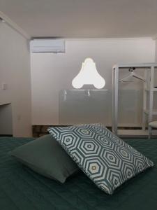 Dormitorio con cama con almohada y lámpara en Casa Flavia, en Anacapri