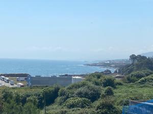 a large building on a hill with a body of water at Apt Sueiras in Burela de Cabo