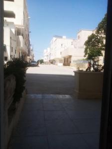 an empty street in a city with white buildings at CIT Y Khadra in Tunis