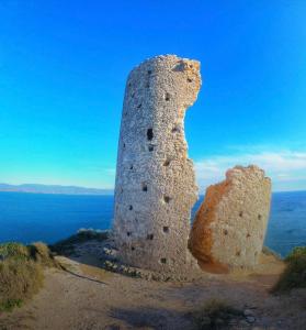 uma torre de pedra no topo de uma colina junto ao oceano em APPARTAMENTO SUITE SARDINIA HOLIDAY em Cagliari